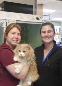 Dr. Siddall holding an orange cat and Dr. McGuirk 
